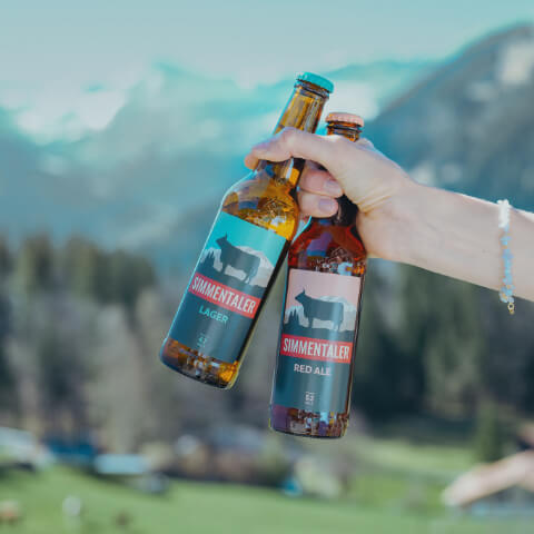 Hand hält 2 Flaschen Simmentaler Bier